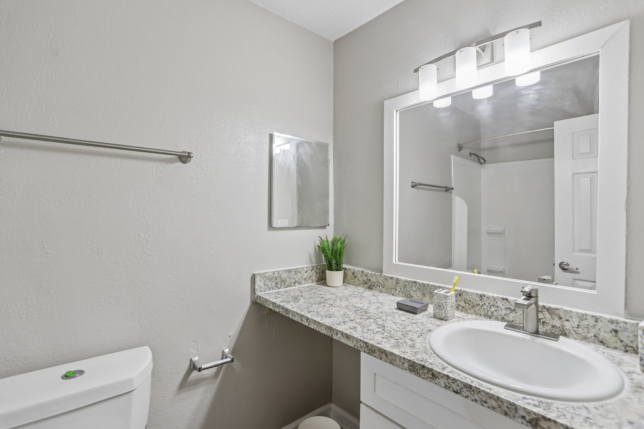 A bathroom with a white sink and a white toilet.